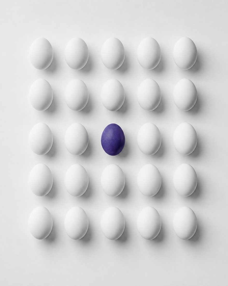 Conjunto de huevos en blanco y negro con uno destacado en morado eléctrico