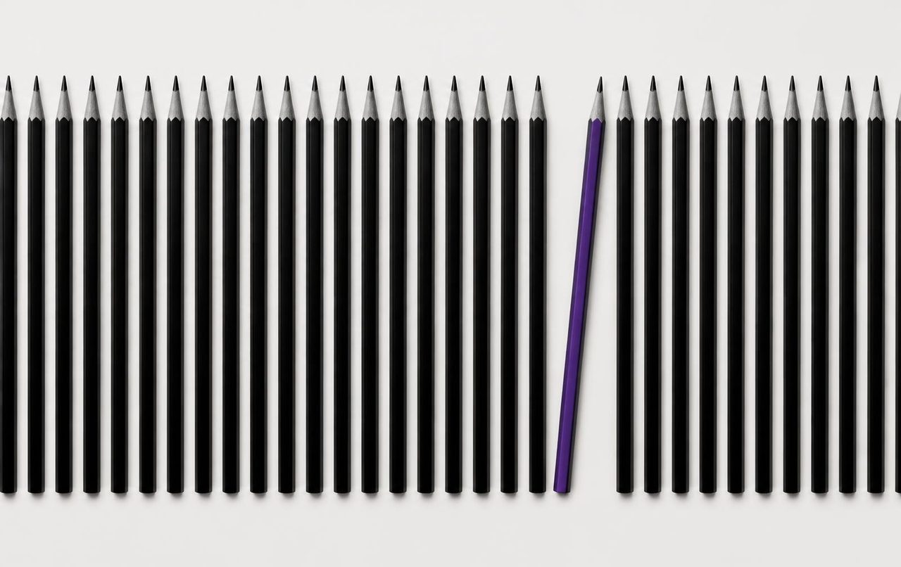 Conjunto de lápices en blanco y negro con uno destacado en morado eléctrico